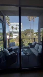 a living room with a couch and a patio with palm trees at Center of Hollywood in Los Angeles