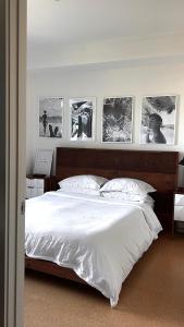 a bedroom with a white bed with pictures on the wall at Center of Hollywood in Los Angeles