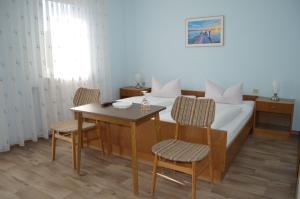 a bedroom with a bed and a table and chairs at Gasthof-Pension Fränkische Schweiz Obertrubach in Obertrubach +3 photos