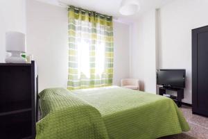 ボローニャにあるGreenHouseBolognaのベッドルーム(緑色のベッド1台、テレビ付)