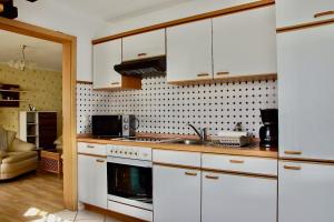 Ferienhaus "Urlaub in Mecklenburg" في Grabowhöfe: مطبخ بخزائن بيضاء ومغسلة