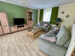 Ferienhaus "Urlaub in Mecklenburg" في Grabowhöfe: غرفة معيشة مع أريكة وتلفزيون