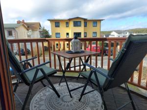 a patio with two chairs and a table on a deck at Moderne Ferienwohnung "Parkblick" im Ostseebad Ückeritz in Ueckeritz