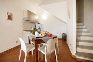 a dining room with a table and white chairs at Casa Atena in Motta D'affermo +13 photos