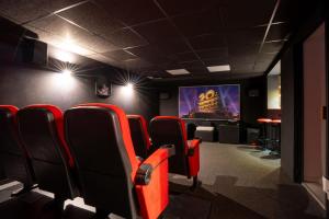 Una sala de espera con sillas rojas y una pantalla. en Villa Summer Wind, en Le Grau d'Agde