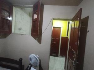 a room with an open door and a room with a fan at Quartos individuais na saída do metrô estação Glória in Rio de Janeiro