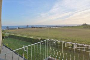 a balcony with a view of a field and the ocean at Hafenblick Whg 15 in Grömitz