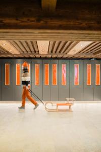 a person is pulling a sled in a room at Hotel Glemmtalerhof in Saalbach Hinterglemm