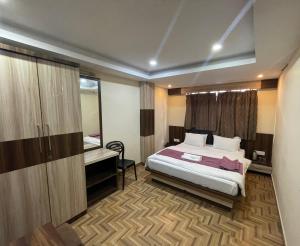 a bedroom with a bed and a desk and a mirror at Hotel Oak in Namchi