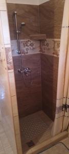una ducha con puerta de cristal en un baño en Rozika Apartman I, en Hajdúszoboszló
