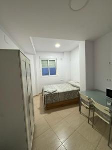 a bedroom with a bed and a desk and a window at TourismCasa in Dos Hermanas