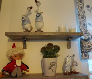 a shelf with three figurines of chickens and a doll at Reethaus "Frieda" in Zierow