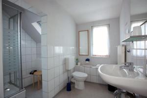 ein weißes Badezimmer mit Toilette und Waschbecken in der Unterkunft Restaurant-Pension Bürgerhof in Bad Zwesten + 1 Foto