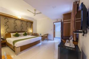 a bedroom with a bed and a flat screen tv at Treebo Trend Akshaya Lalbagh Inn in Bangalore