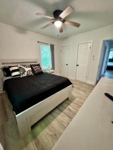 a bedroom with a bed with a ceiling fan at 3 miles to Ft Benning - Cozy Family Retreat in Columbus