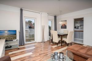 a living room with a table and a dining room at Haus Godewind Ferienwohnung 10 mit Balkon und Strandkorb in Binz +13 photos