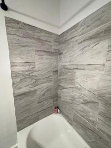 a bathroom with a tub and a stone wall at 3 miles to Ft Benning - Cozy Family Retreat in Columbus