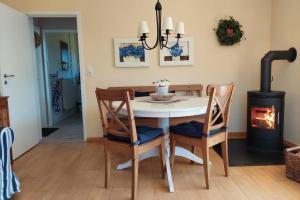 ein Esszimmer mit Tisch und Holzofen in der Unterkunft Deelswai 50, Bungalow in Goting