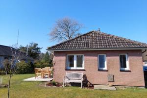 ein kleines Backsteinhaus mit einer Bank im Hof in der Unterkunft Deelswai 50, Bungalow in Goting