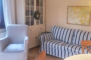 ein Wohnzimmer mit einer Couch und einem Sessel in der Unterkunft Deelswai 50, Bungalow in Goting