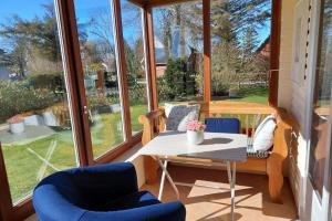 eine abgeschirmte Veranda mit einem Tisch und Stühlen in der Unterkunft Deelswai 50, Bungalow in Goting