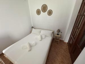 ein Schlafzimmer mit einem weißen Bett mit Fliegen darauf in der Unterkunft Apartamento Teresa - Centro de Campillos in Campillos