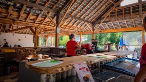 una mujer parada en un mostrador de madera en un edificio en Camping Valloire-sur-Cisse, en Seillac