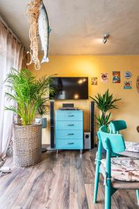 ein Zimmer mit einer blauen Kommode und einem Fernseher in der Unterkunft Mano Malibu in Melnragė