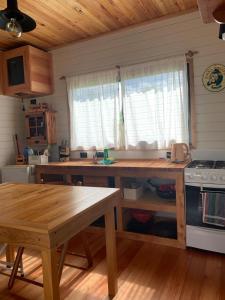 - une cuisine avec une table en bois et une cuisinière dans l'établissement Minicasa Ensueño, à Colonia Hocker