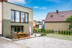 ein Haus mit einer Terrasse mit Tisch und Stühlen in der Unterkunft Mano Malibu in Melnragė
