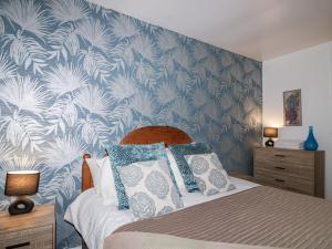 a bedroom with a bed with blue and white wallpaper at Valley Lodge 20 in Callington +40 photos