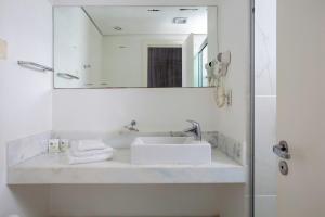 a white bathroom with a sink and a mirror at Pampulha Design Hotel in Belo Horizonte +60 photos