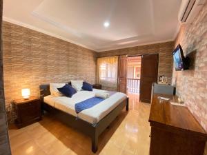 Un dormitorio con una cama y un televisor. en ABI Hotel2 - 1 minute to the Beach and 1 second to the Mall, en Ngurah Rai International Airport