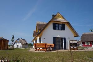 a house with a bench in front of it at Reethaus "Calappa" in Zierow