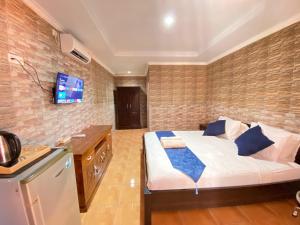 a bedroom with a bed and a tv on a brick wall at ABI Hotel2 - 1 minute to the Beach and 1 second to the Mall in Ngurah Rai International Airport