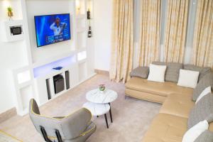 a living room with a couch and a tv at Suit 360 Abuja in Abuja