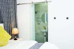 a bedroom with a shower and a bed and a sink at Suit 360 Abuja in Abuja +35 photos