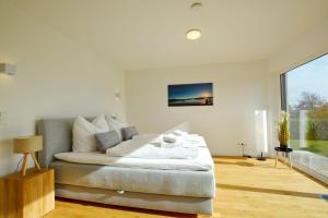 a bedroom with a large bed and a large window at Berg- und Seeblick in Breitbrunn