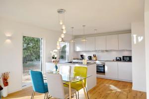 a kitchen with a glass table and chairs at Berg- und Seeblick in Breitbrunn