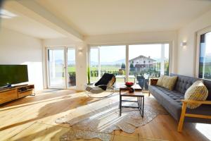 a living room with a couch and a tv at Berg- und Seeblick in Breitbrunn