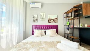 ハルキウにあるNew apartment with smart TVのベッドルーム(紫色のヘッドボード付きの大型ベッド1台付)