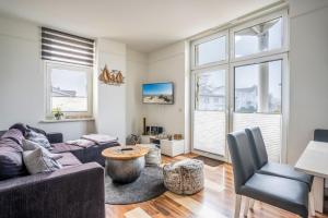 a living room with a couch and a table at Haus Godewind Ferienwohnung 5 mit Balkon und Strandkorb in Binz