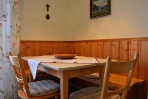 mesa de comedor con 2 sillas y una cruz en la pared en Alpenzauber, en Bernau am Chiemsee