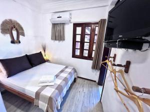 a bedroom with a bed and a flat screen tv at Casa Jeri Guarani in Jericoacoara
