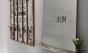 two pieces of art on a wall next to a mirror at Lütt Kirr in Zingst