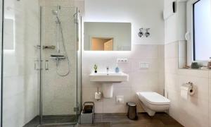 a bathroom with a shower and a sink and a toilet at Lütt Kirr in Zingst +19 photos