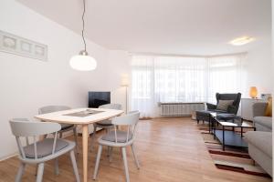 un salon avec une table, des chaises et un canapé dans l'établissement Grömitz-Center Whg 431, à Grömitz