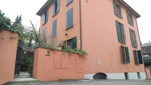 an orange building with a red door and plants on it at All' Ombra del Portico in Bologna