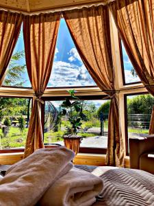 a bedroom with a large window with a view of a yard at Forest Glamp & Jacuzzi in Zakopane