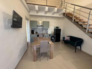 a living room with a dining room table and a staircase at Sole di Sicilia in Locogrande